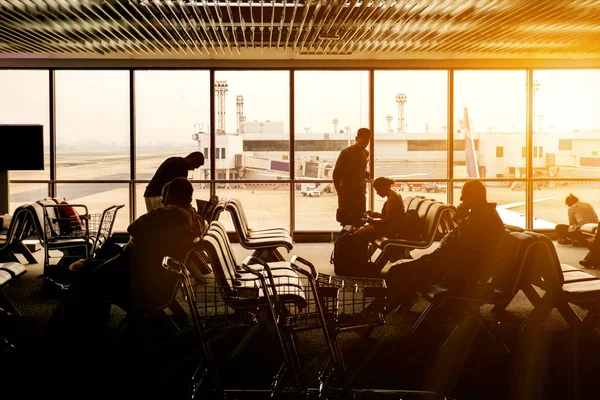 Silhouette Insanlar Turist Bekleyen Bir Havaalanı Uçak Güneş Patlaması Arka — Stok fotoğraf
