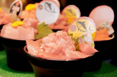 Tatlı Japon taze ve çiğ gıda (ton balıklı sashimi) siyah kase satışa Kuromon sokak pazarı, Osaka, Japonya. Ton balıklı sashimi Japonya ziyarete geldiğinde turistler arasında popüler ve pahalı.
