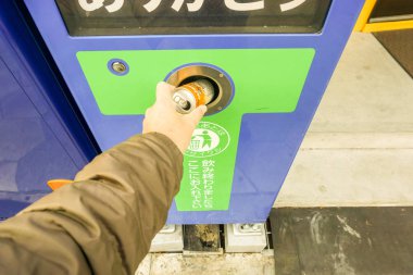Osaka, Japonya 17 Ağustos 2018: el meşrubat atılması bir insan geri dönüşüm çöp makinesi için takas bu paralar için.