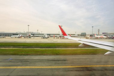 Bangkok, Tayland 11 Mayıs 2018: uçak görünümünü sırasında uçağın Havaalanı Pist üzerinde dışında mavi gökyüzü ve birçok hava uçak ve terminal binası arka plan ile almaya hazır olduğunu.