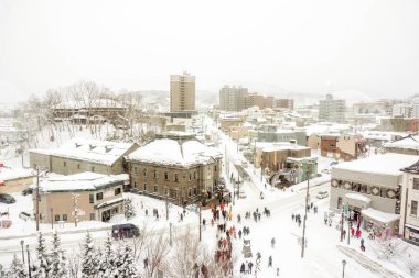 Otaru, Hokkaido ili, Japonya, 14 Şubat 2018: yüksek açılı görünüş kar maskeli Otaru şehir Meruhen kesişme noktalarında alanda birçok kişi ve kış sisli gökyüzü arka plan üzerinde turist ile.
