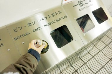 Osaka, Japonya 21 Şubat 2018: el insan düşüyor kahve için alüminyum sınıflandırmak çöp kutusu.