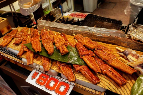 Giant Japanese grilled eels fish (Anguilla japonica) for sale with Japanese price label at Kuromon ichiba market, Osaka, Japan. Japanese grilled eels fish are luxury and expensive of Japanese food.