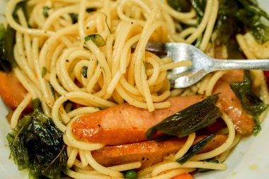 Tatlı sosis spagetti çatalı arka plan ve wllpaper beyaz seramik plaka üzerinde Tay tarzında.