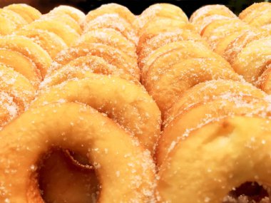 Portre ve ürün bir sürü raf pastane dükkanı arka plan ve duvar kağıdı üzerinde şekerli çörek. Halka bir koroner arter hastalığı ve obezite hastalığı neden olur.