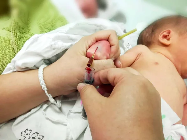 Hasta yeni doğan bebek yandan IV kateter bıçak kullanarak ve onun kana-kan tüpü için check-up glikoz ve tüm virüs NICU wards, kanında süzülmüş çocuk hemşiresi, eller.