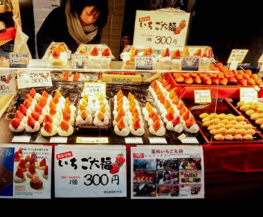 Osaka, Japonya, 16 Şubat 2018: dolu büyük mochi çilek Japonlarla bir ekran kabine ile fiyat ve ad etiketleri. Renkler ve şekiller turist Kuromon Ichiba piyasada satın almak için davet.