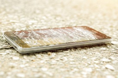 Portre siyah cep telefonu kaza geri dönmesine yol ve güneş patlaması arka plan ile kırık camlar.