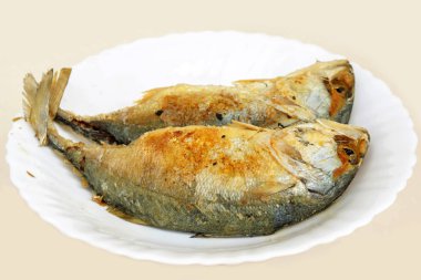 Beyaz seramik tabak ve pembe bir arka plan üzerinde kızarmış mackerels (Rastrelliger brachysoma). Fried mackerels Tayland yemek ve Tay karides yemek için popüler chili sos (Nam Phrik Kapi yapıştırın).