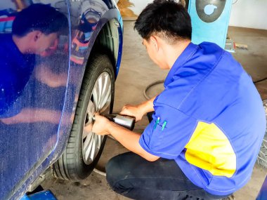 Lampang, Thailand, 26 Ekim 2018: mavi araba garajda Closeup araba mekanik tutun ve lastik değiştirme elektrik pnömatik silah kullanma