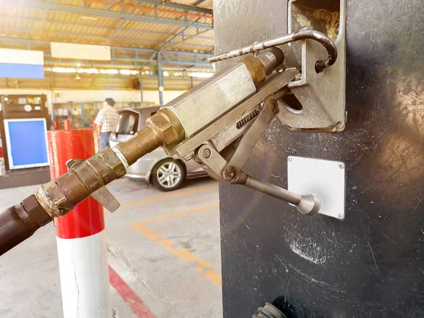 太陽フレアの背景を持つガソリンスタンドでぼやけた顧客の自動車用クローズアップガスディスペンサー — ストック写真