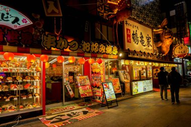 Osaka, Japonya, 14 Ocak 2019 : Gece saatlerinde Shinsekai walking street'te şehir gece hayatı ile Japon restoran tabelasının perspektif görünümü.