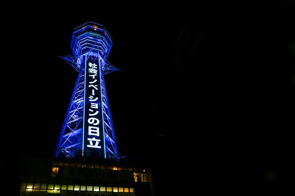 日本大阪 2019年1月14日 筑地塔与蓝色霓虹灯和日文字母在夜间背景 筑地是大阪的一座塔楼和地标 总高度为103米 — 图库照片