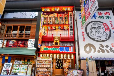 Osaka, Japonya, 14 Ocak 2019 Osaka alışveriş caddesinde altın çocuk tanrı Billy Ken ile Japon restoranının benzersiz ve renkli tabelası..