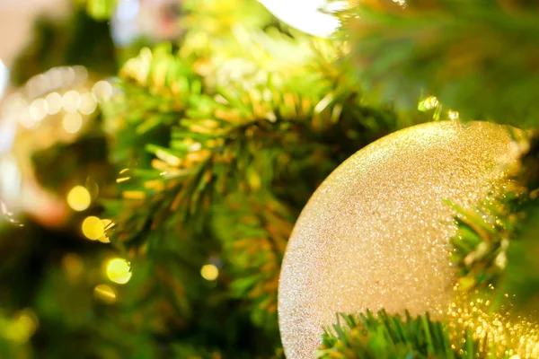 Bola de Navidad de oro de primer plano decorada en pino en Navidad — Foto de Stock