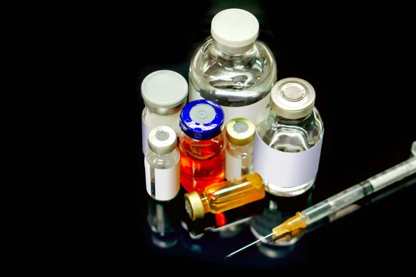 Вакцины и инъекции препарата во флаконе различных размеров с пластмассой — стоковое фото