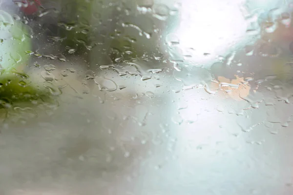 Driver ogen uitzicht op regendruppels op auto voorruit op regenachtige dag. — Stockfoto