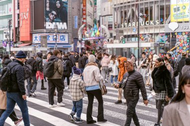 Tokyo şehri, Japonya-13 Aralık 2024: Shibuya 'nın karşıdan karşıya geçen insan ve turist kalabalığının şehir manzarası. Shibuya bölgesi Tokyo 'nun simgesel bir sembolü ve metropolün çabukluğu..