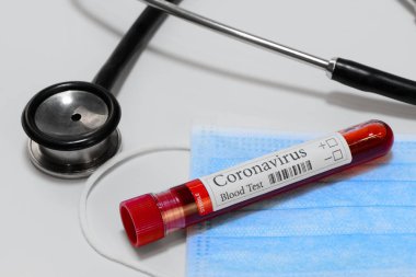 COVID-19 laboratuvar test tüpü ve teşhis koronavirüs enfeksiyonu için laboratuvar örneği yüz maskesi ve stetoskop.