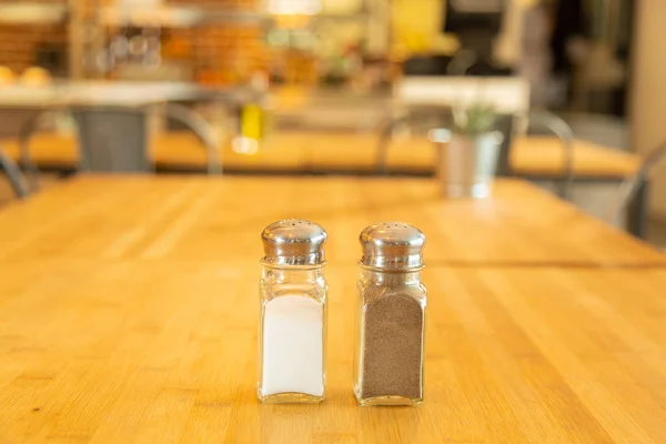 Pepper shaker and salt shaker on a bamboo table