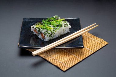 Amerikan rulo ve yemek çubukları siyah arka plan üzerine siyah plaka