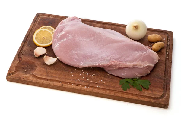 Raw turkey fillet on a wooden cutting board