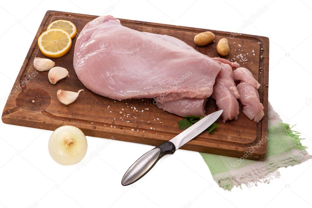 Raw turkey fillet on a wooden cutting board