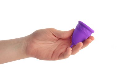 Beyaz arka planda mor mensturel bardağı tutan el.