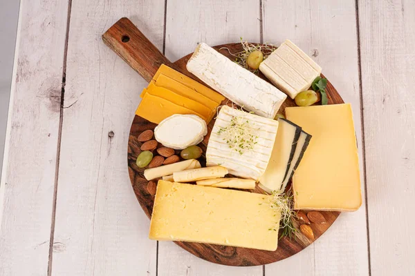 Verschiedene Käsesorten Auf Einem Brett Auf Einem Holztisch — Stockfoto