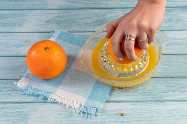 Mavi arka planda meyve suyu yapmak için portakal suyu