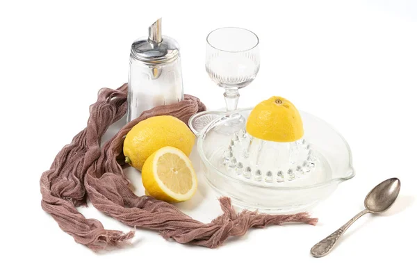 Lemon and lemon squeezer in glass on a white background