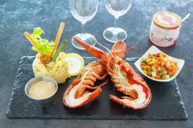 Sebzelerle dolu bir tahtada ikiye bölünmüş ıstakoz.