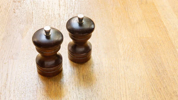 Salt and pepper mills on a wooden table