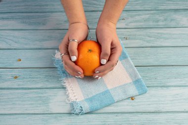 Mavi ahşap arka planda tutulan portakal.