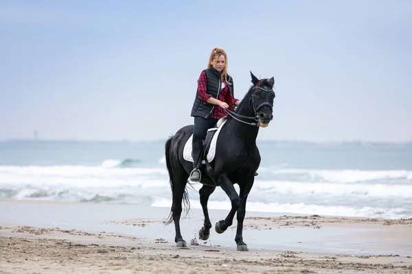 Μια Νεαρή Γυναίκα Πάνω Ένα Άλογο Στην Παραλία Μια Συννεφιασμένη — Φωτογραφία Αρχείου