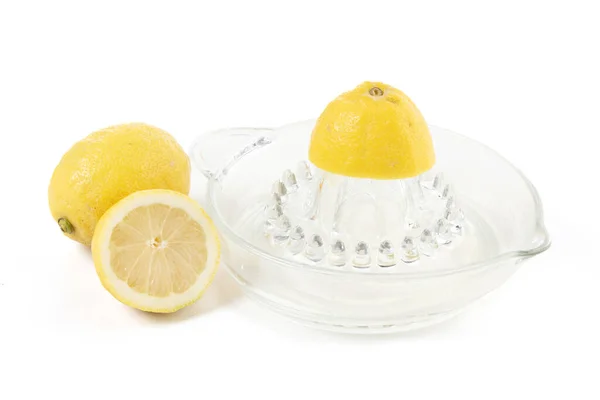 Lemon and lemon squeezer in glass on a white background