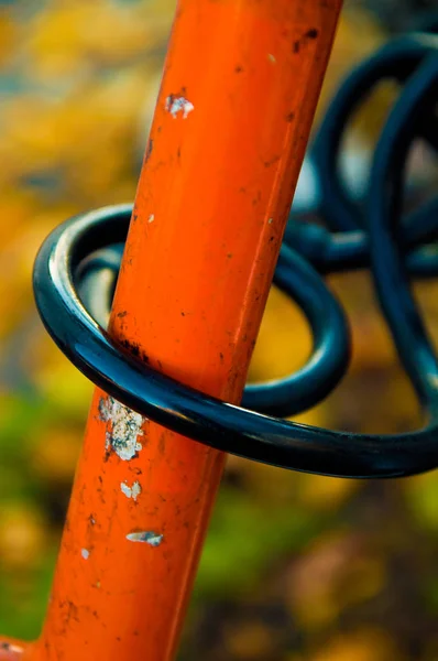 A closeup of a black bike lock on a colorful, retro bike.