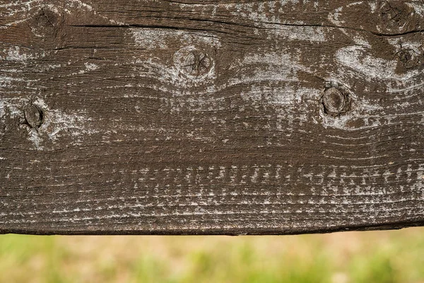 Szorstka Rustykalna Ciemnobrązowa Deska Drewniana Wyblakłą Powierzchnią Zamazaną Naturą Tle — Zdjęcie stockowe