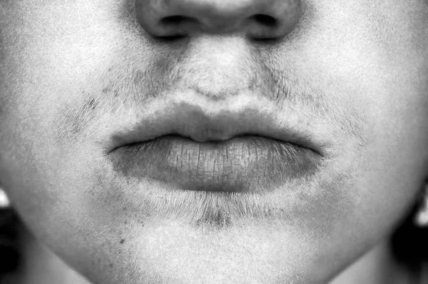 Close-up detail van de jonge Kaukasische tiener mannetjes mond en lippen met zachte baard en snor in zwart-wit - Concept van jeugd onveiligheid gevoelens, rustig zwijgen innerlijke pijn of geheime ongelukkig emo — Stockfoto
