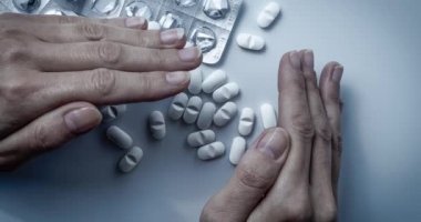 Eller kapsar ve birçok beyaz reçeteli ilaçlar, ilaç tabletleri veya vitamin hapları bir kazık gizleme-sağlık kavramı, opioidler bağımlılığı, utanç, ilaç istismar veya ilaç tedavisi