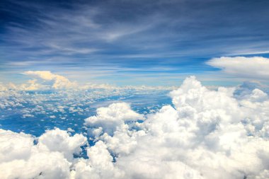 Uçak penceresinden beyaz bulutların üzerindeki güzel mavi gökyüzü manzarası 