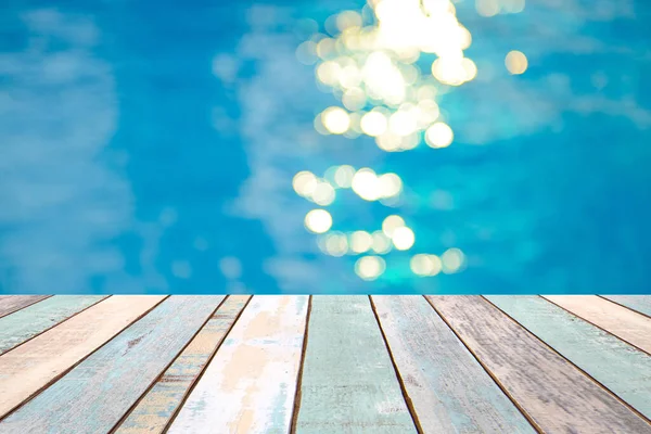 Perspektif ahşap masa üstü ve yumuşak odak ışığı efektleri havuzda dalgalı, mavi su arka planı, ürün ekran montajı 