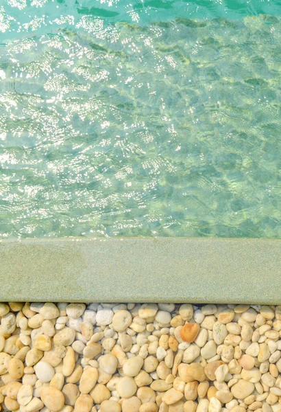 在明亮的蓝色游泳池前 用石头围起来 用阳光反射 出游等方式装饰和设计游泳池 — 图库照片