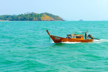 PHUKET, THAILAND - 24 Mart 2015: Phuket adasında Andaman Denizi 'nin mavi sularında uzun kuyruklu tekneyle seyahat eden turistler. - 24 Mart 2015, Phuket, Tayland.