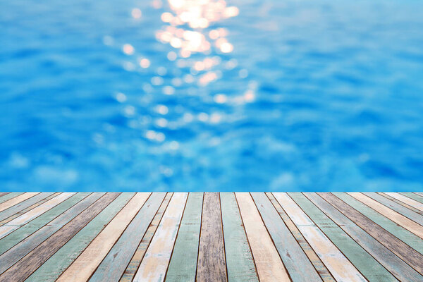 Wood table top on blur background of refraction in water and Beautiful sunrise on the sea - can be used for display or montage your products