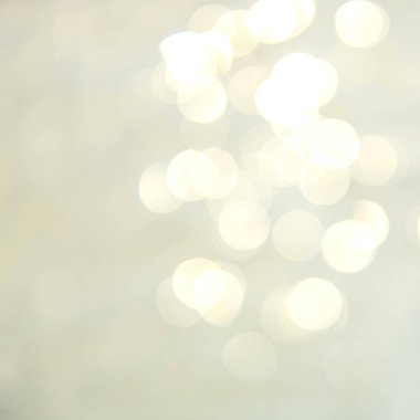 Plajdaki dalgalı, mavi su arkaplanı üzerine yumuşak odak ışığı efektleri.