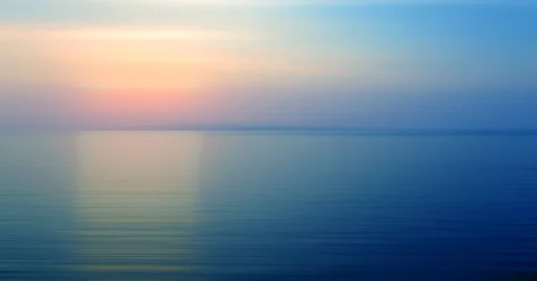 要旨夕暮れ時に海に沈む夕日と水の屈折の背景の動きがぼやけている — ストック写真