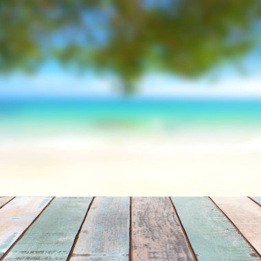 Bulanık doğa manzaralı ahşap masa üstü tropik plaj ve mavi gökyüzü, tatil arka planı konsepti ürününüzü görüntülemek veya montajlamak için kullanılabilir.