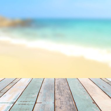 Bulanık doğa manzaralı ahşap masa üstü tropik plaj ve mavi gökyüzü, tatil arka planı konsepti ürününüzü görüntülemek veya montajlamak için kullanılabilir.