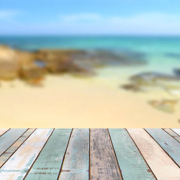 Wood table top with blurred nature scene tropical beach and blue sky, holiday background concept - can be used for display or montage your product
